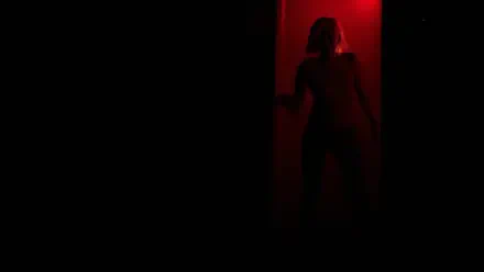 2K Quad HD PC wallpaper of Grace Ashcroft from Resident Evil Requiem: a shadowy female silhouette framed in a narrow red-lit doorway against an almost black background.