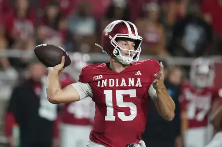 4K Ultra HD PC wallpaper of a football quarterback in a red Indiana jersey No. 15 winding up to throw amid a packed stadium — sports/NFL themed desktop background.