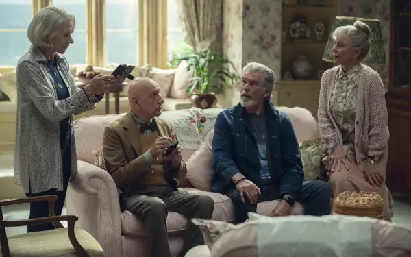 8K Ultra HD PC desktop wallpaper of four older friends from the movie The Thursday Murder Club sitting and chatting in a cozy, floral living room.