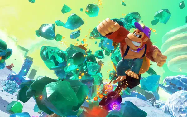 Donkey Kong Bananza HD PC desktop wallpaper and background: Donkey Kong bursts through flying emerald crystals across a snowy, ruined landscape beneath a vivid green sky.
