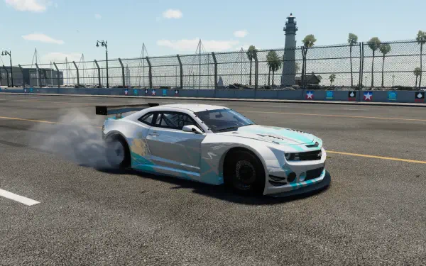 Bright daytime HD PC desktop wallpaper of a Chevrolet Camaro drifting on a sunlit circuit in The Crew, blue-white livery kicking up smoke near palm-lined barriers.