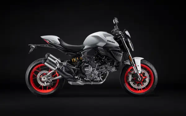 Side profile of a silver Ducati Monster motorcycle with red rims on a dark backdrop, 5K Ultra HD PC desktop wallpaper/background.