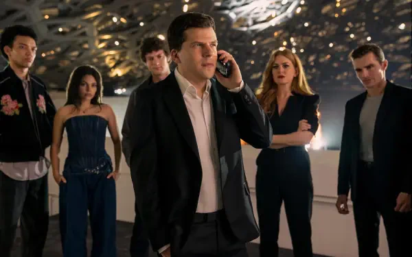 Group cast shot from the movie Now You See Me: Now You Don't — man in suit on phone at center with teammates behind him; 2K Quad HD PC desktop wallpaper.