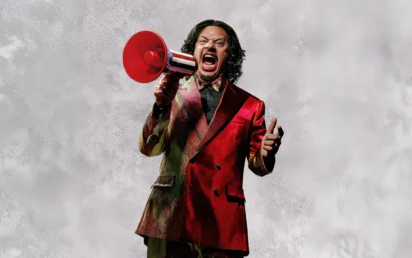 Street Fighter (2026) 5K Ultra HD PC desktop wallpaper: a person in a red suit shouting into a red megaphone against a cloudy gray backdrop.