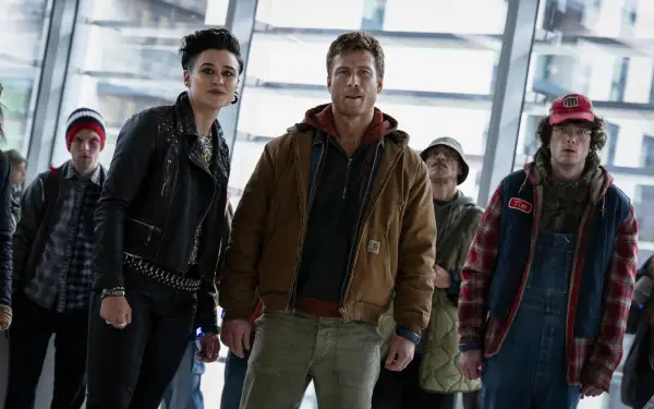 4K Ultra HD PC desktop wallpaper: cinematic scene from the movie The Running Man — a group of wary figures standing in a bright glass atrium.