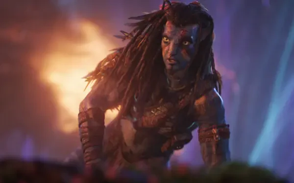 Avatar: Fire and Ash 4K Ultra HD PC desktop wallpaper — blue-skinned Na'vi-style warrior with dreadlocks and war paint crouches amid glowing embers, fire and ash swirling behind.