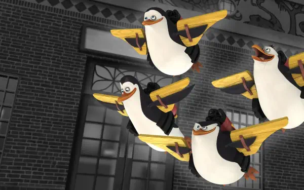 The Penguins of Madagascar in mid-flight over a brick city facade — 4K Ultra HD PC desktop wallpaper and background.