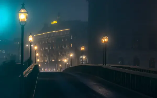 5K Ultra HD PC desktop wallpaper: nighttime city haze with a bridge lit by street lamps leading toward softly glowing buildings.