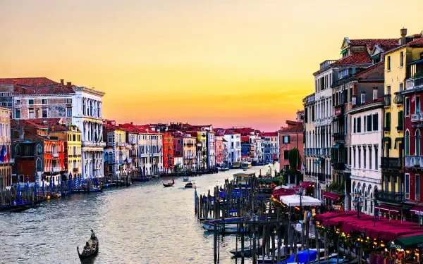 4K Ultra HD PC desktop wallpaper of Venice, Italy: a man-made canal at sunset, colorful historic buildings, gondolas and waterfront cafés along the Grand Canal.
