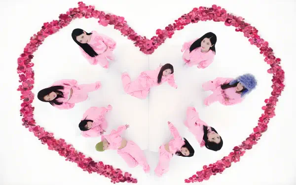 K-pop–inspired album-style 4K desktop wallpaper: nine performers in pink outfits arranged inside a heart of pink roses on a white background.