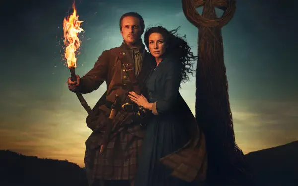 Outlander 4K Ultra HD PC desktop wallpaper: a man in a kilt holding a torch and a woman in period dress embrace beside a standing Celtic cross at sunset.
