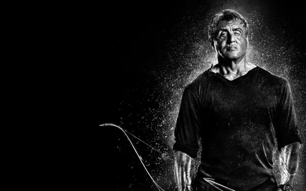 Rambo: Last Blood HD PC desktop wallpaper/background — gritty black-and-white portrait of a lone, battle-worn hero holding a bow, rain and dust highlighting his silhouette.