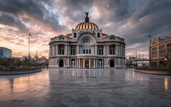 Ornate domed theater facing a polished marble Constitution Plaza in Mexico City under a dramatic sky; 2K Quad HD PC desktop wallpaper highlighting Mexican architecture and marble details.