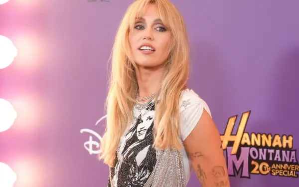 Hannah Montana TV show 2K Quad HD PC wallpaper: blonde actress portraying Hannah Montana posing against a purple backdrop with illuminated mirrors and the show's logo.