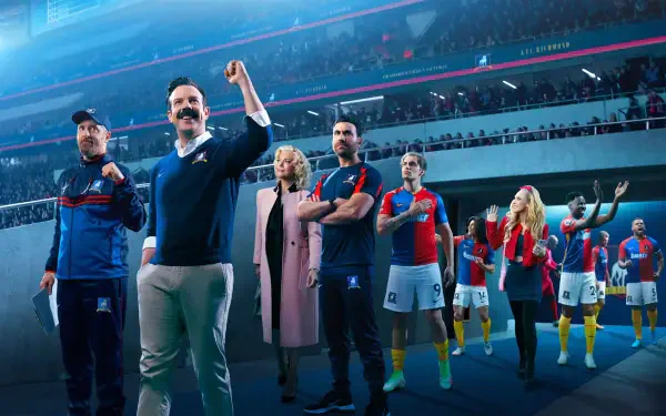 4K Ultra HD PC wallpaper of Ted Lasso and his team entering a packed stadium: coach raising a fist while players and staff follow under bright stadium lights.