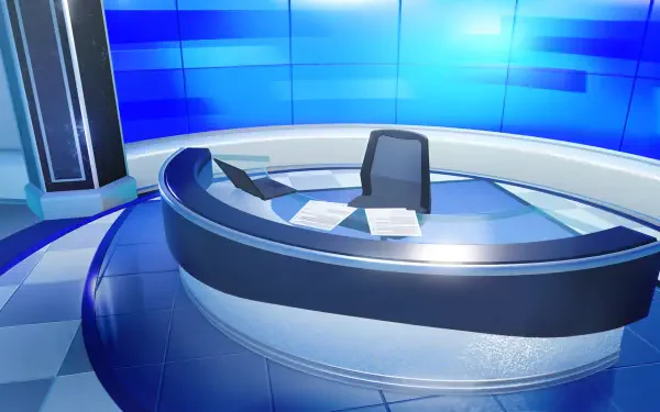 HD PC desktop wallpaper: Tomodachi Life, Tomodachi Life: Living the Dream — blue broadcast studio with curved anchor desk, chair, laptop and papers on glossy tiled backdrop.