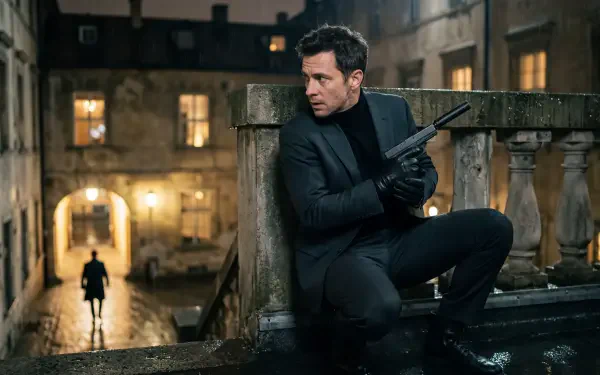Secret Agent 5K Ultra HD PC desktop wallpaper: a suited agent crouches on a stone balcony at night, gun in hand, surveilling a lone figure on a wet cobblestone street.