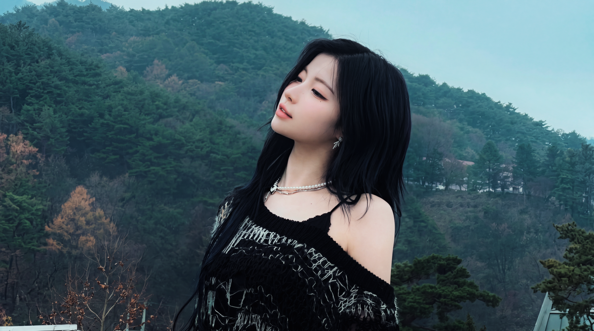5K Ultra HD desktop wallpaper of a moody goth/emo K-pop girl with long dark hair, BABYMONSTER-inspired styling and pearl jewelry, posed against a misty mountain backdrop.