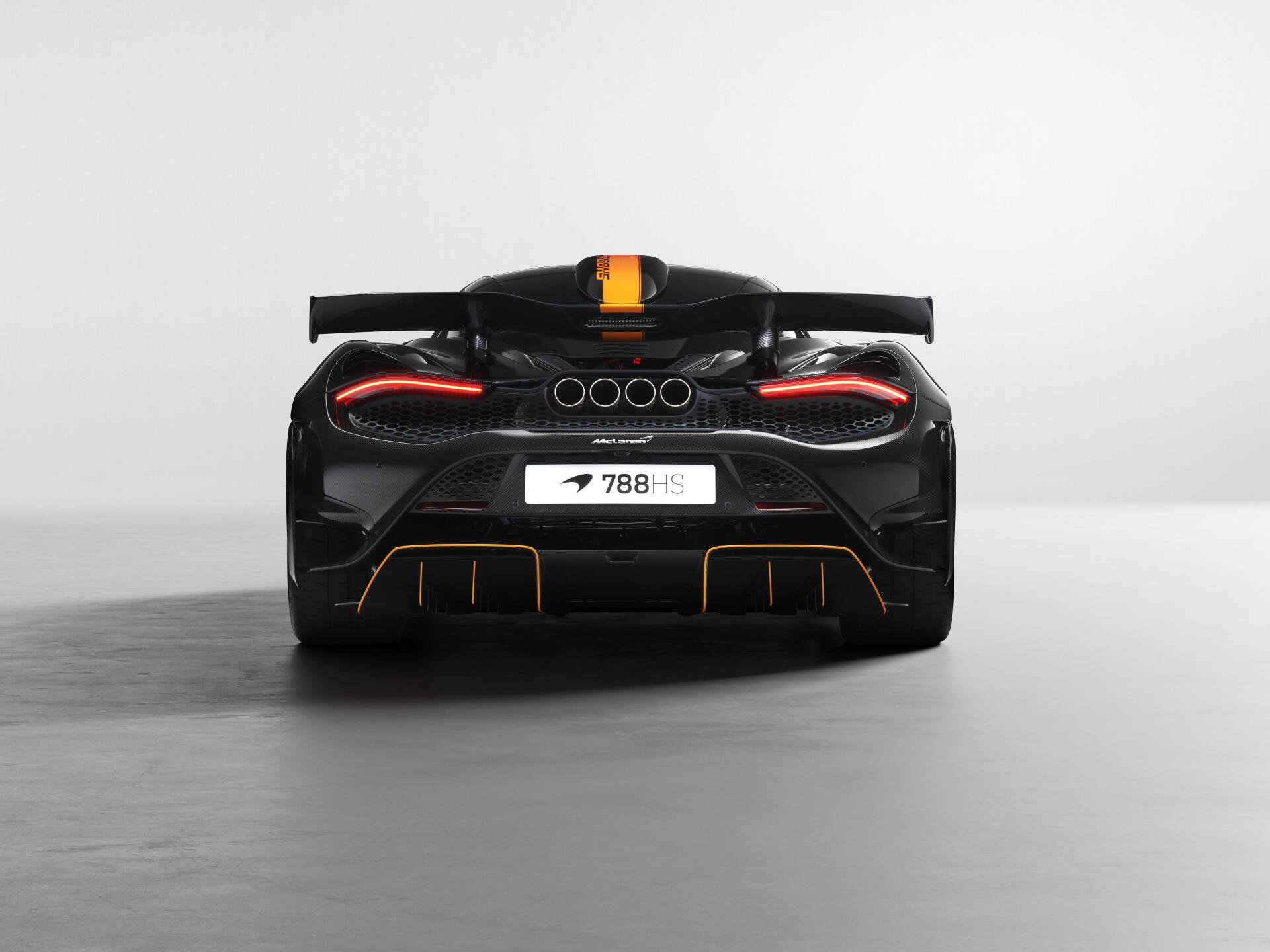 8K Ultra HD PC desktop wallpaper: rear view of a black McLaren 788HS vehicle with glowing taillights, orange racing stripe, and minimalist gray background.