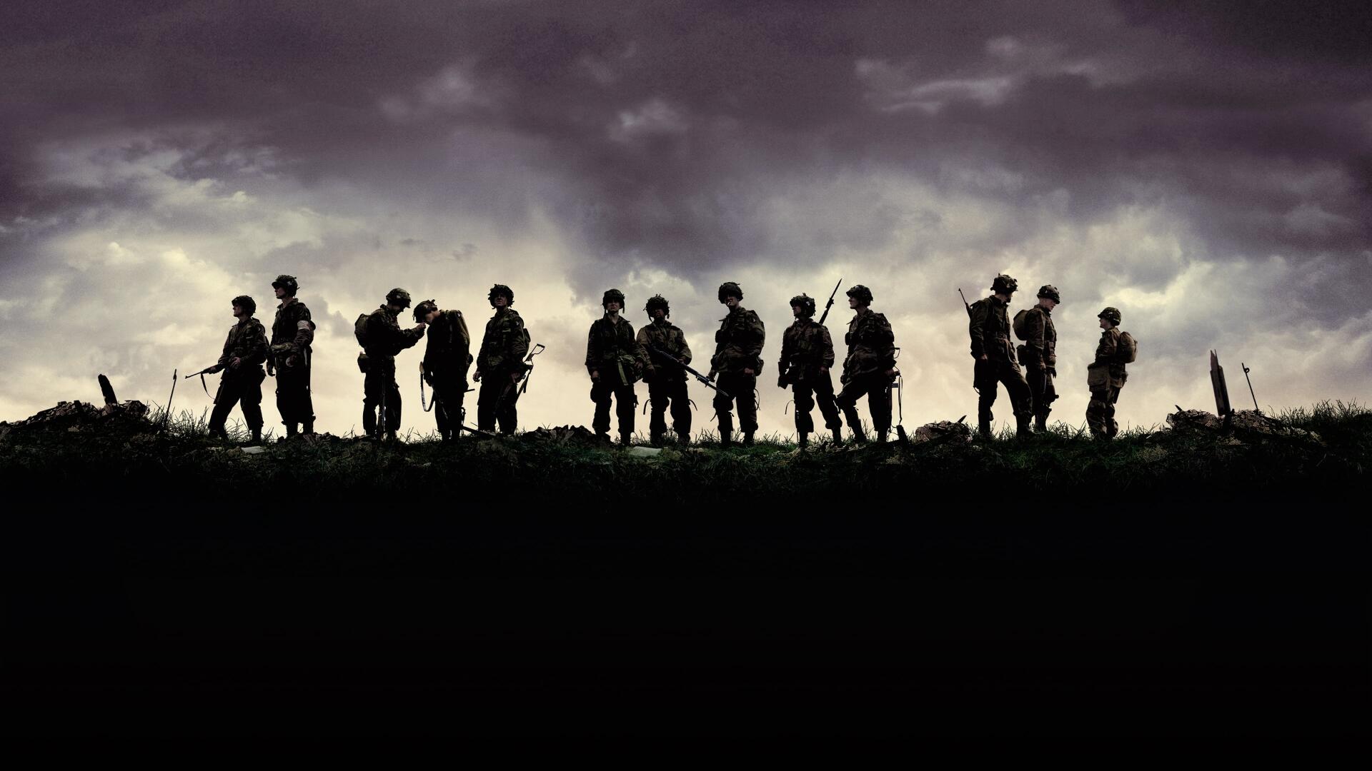 Band Of Brothers 4K Ultra HD PC desktop wallpaper: silhouetted soldiers stand along a ridge under a brooding purple-gray sky, high-contrast cinematic war scene background.