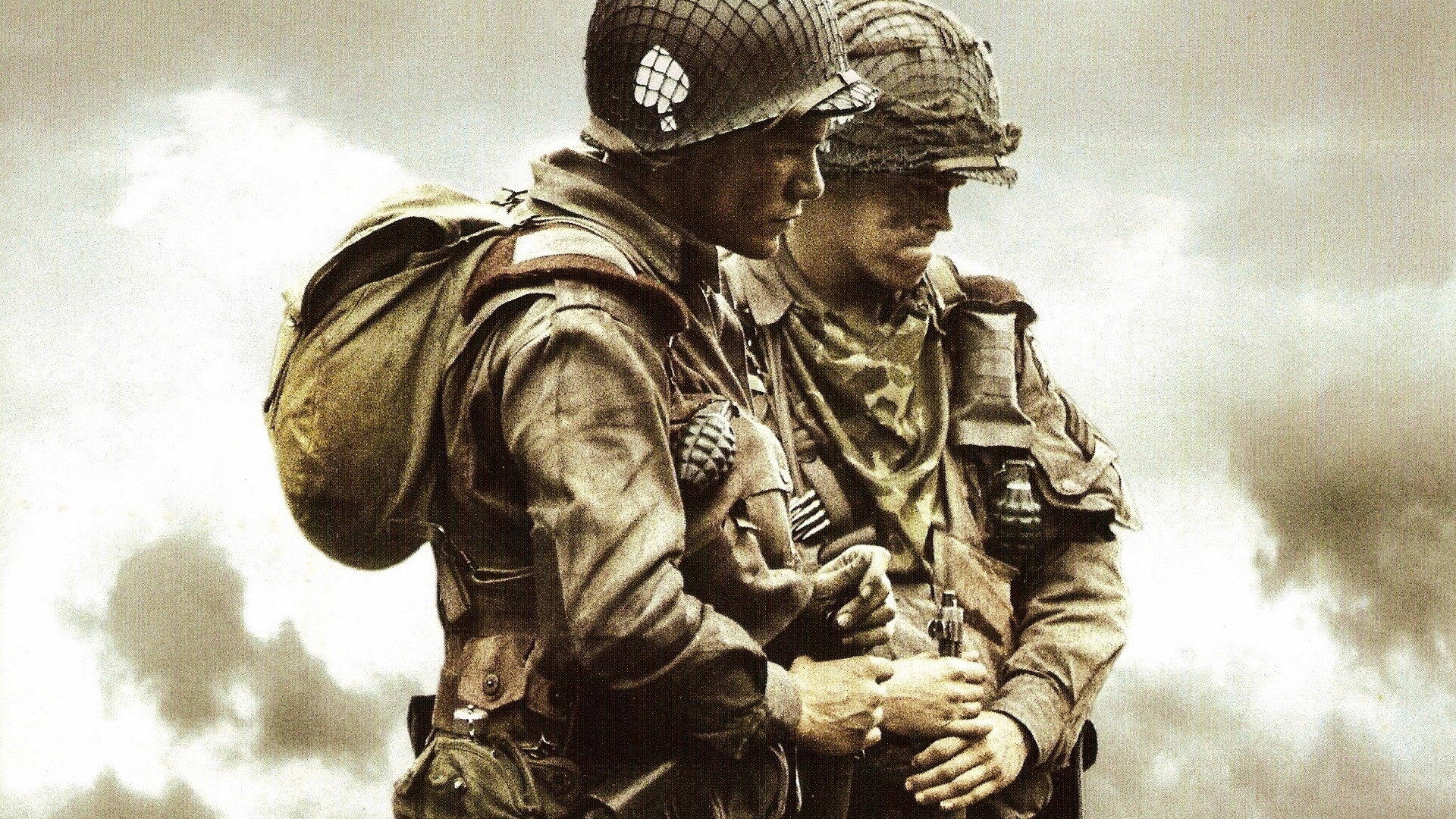 Band of Brothers HD PC desktop wallpaper and background: two World War II soldiers in helmets and gear, one supporting the other amid a smoky, war-torn landscape.