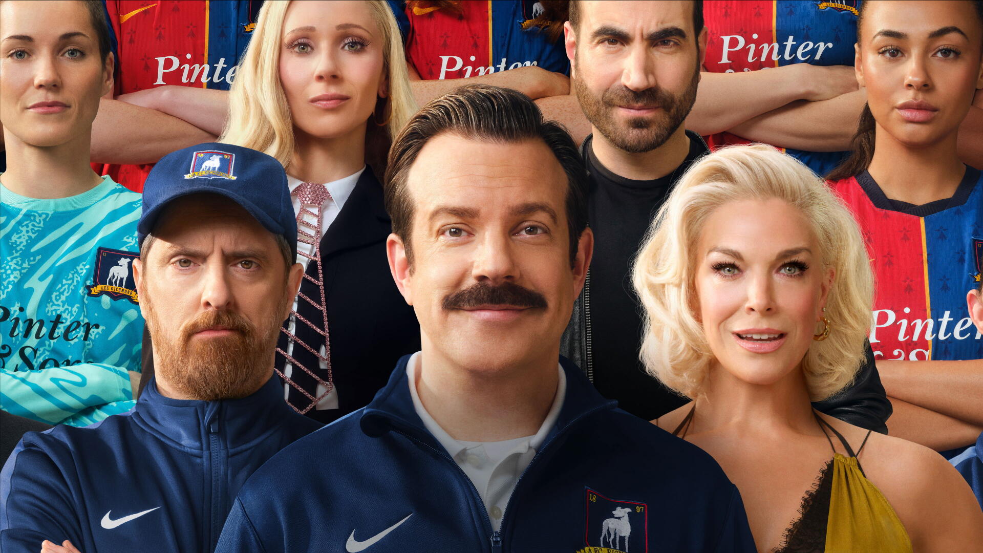 Ted Lasso 4K Ultra HD desktop wallpaper — mustached coach smiling center, surrounded by teammates and staff in team jerseys against a stadium backdrop.
