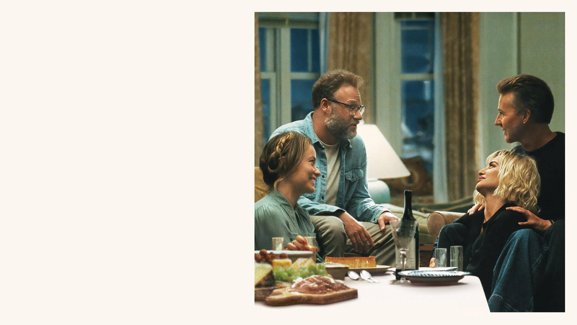 The Invite — candid dinner scene: four people laughing around a table with wine and food in a warm interior. 4K Ultra HD PC Desktop Wallpaper and Background.