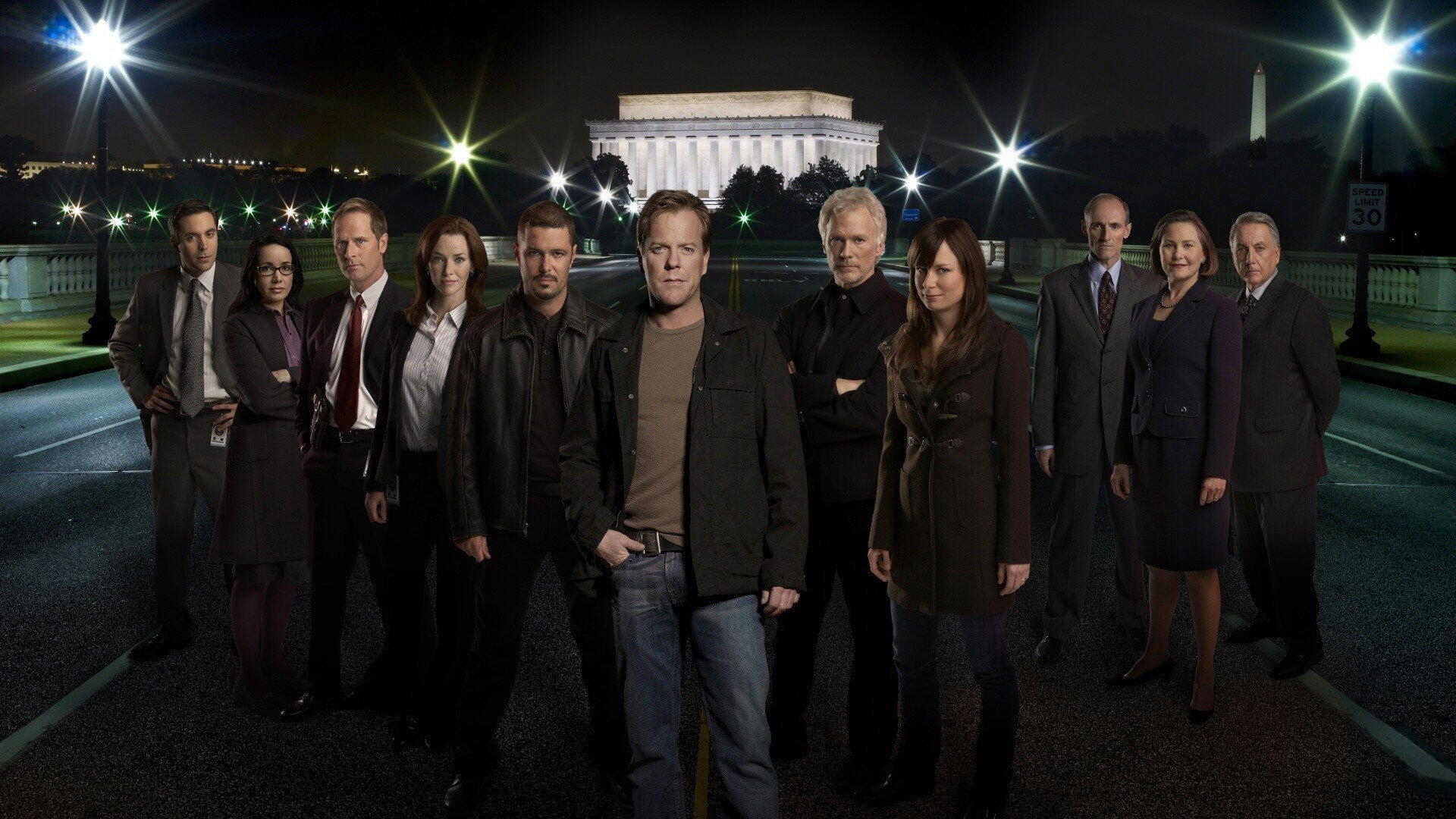 HD PC desktop wallpaper tagged 24: a dozen people stand on a dimly lit bridge at night with an illuminated neoclassical memorial behind them.