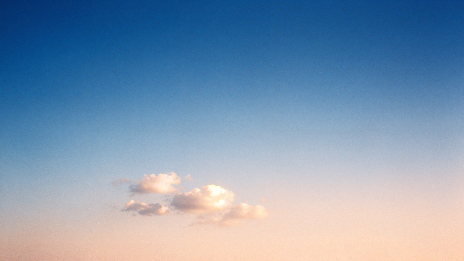 4K Ultra HD PC desktop wallpaper and background: expansive clear sky gradient from deep blue to soft peach with a single fluffy cloud near the horizon.