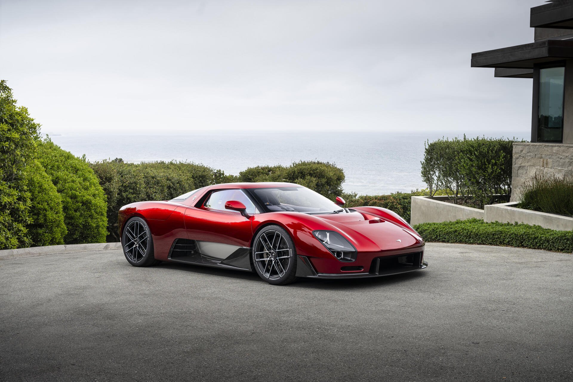 Red McLaren McL 6GT supercar sports car parked by a modern house, 8K Ultra HD PC desktop wallpaper background.