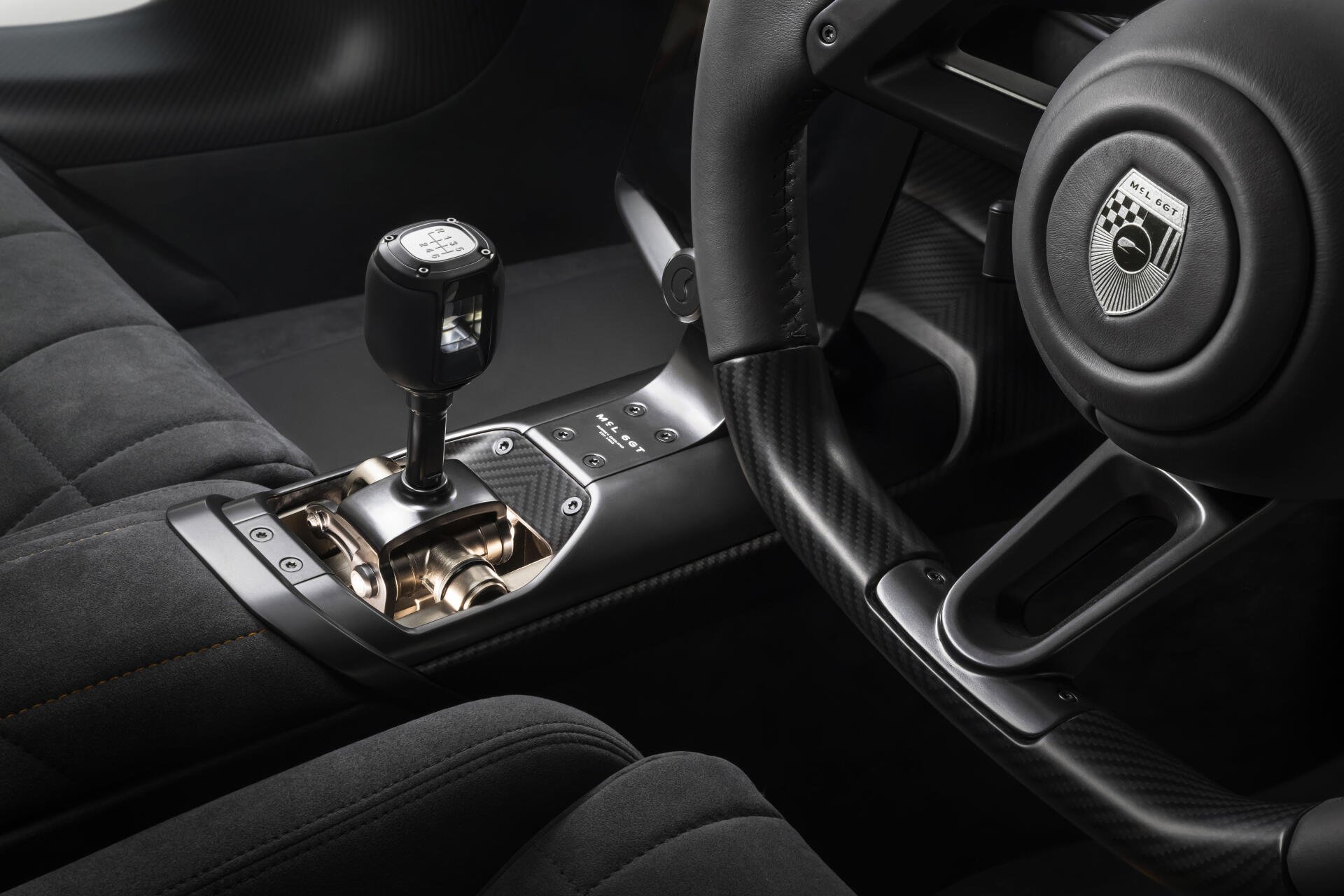 8K Ultra HD wallpaper of McLaren McL 6GT interior, close-up of steering wheel, gated gear shifter and quilted leather upholstery.