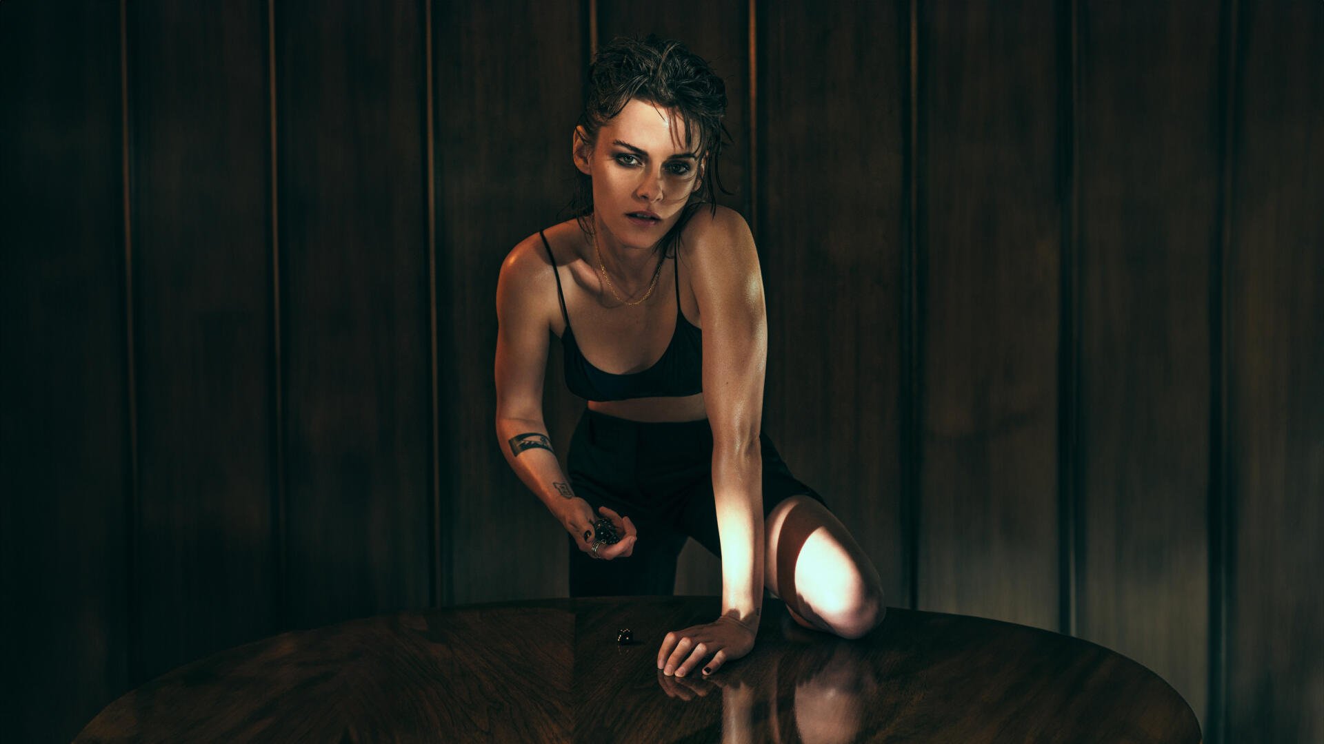 Cinematic portrait of a woman leaning on a table in low light with dramatic shadows — 5K Ultra HD PC desktop wallpaper and background