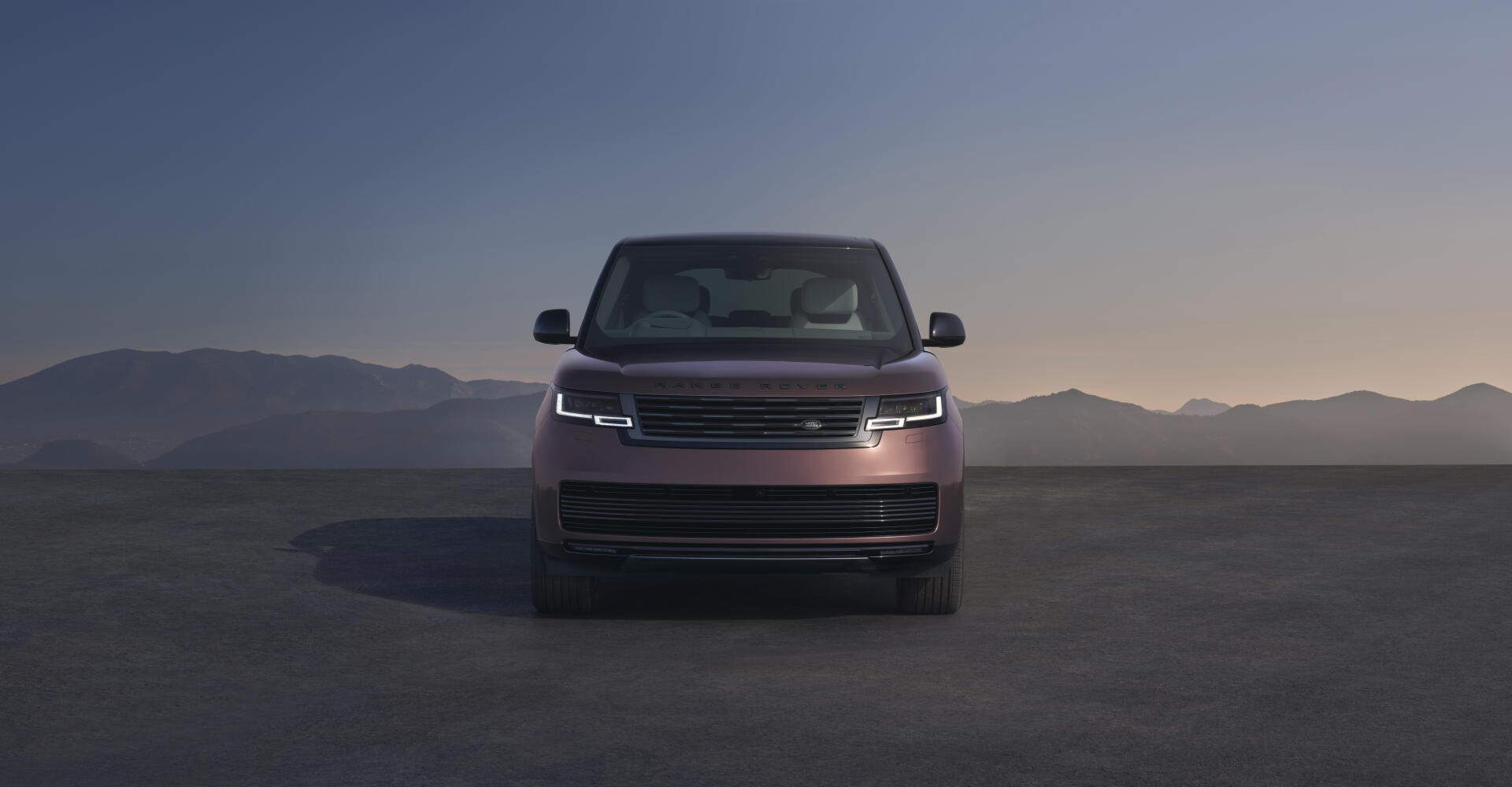 Front view of a Range Rover Electric pickup truck on a flat plain at dusk, Range Rover truck showcased as an 8K Ultra HD PC desktop wallpaper/background.