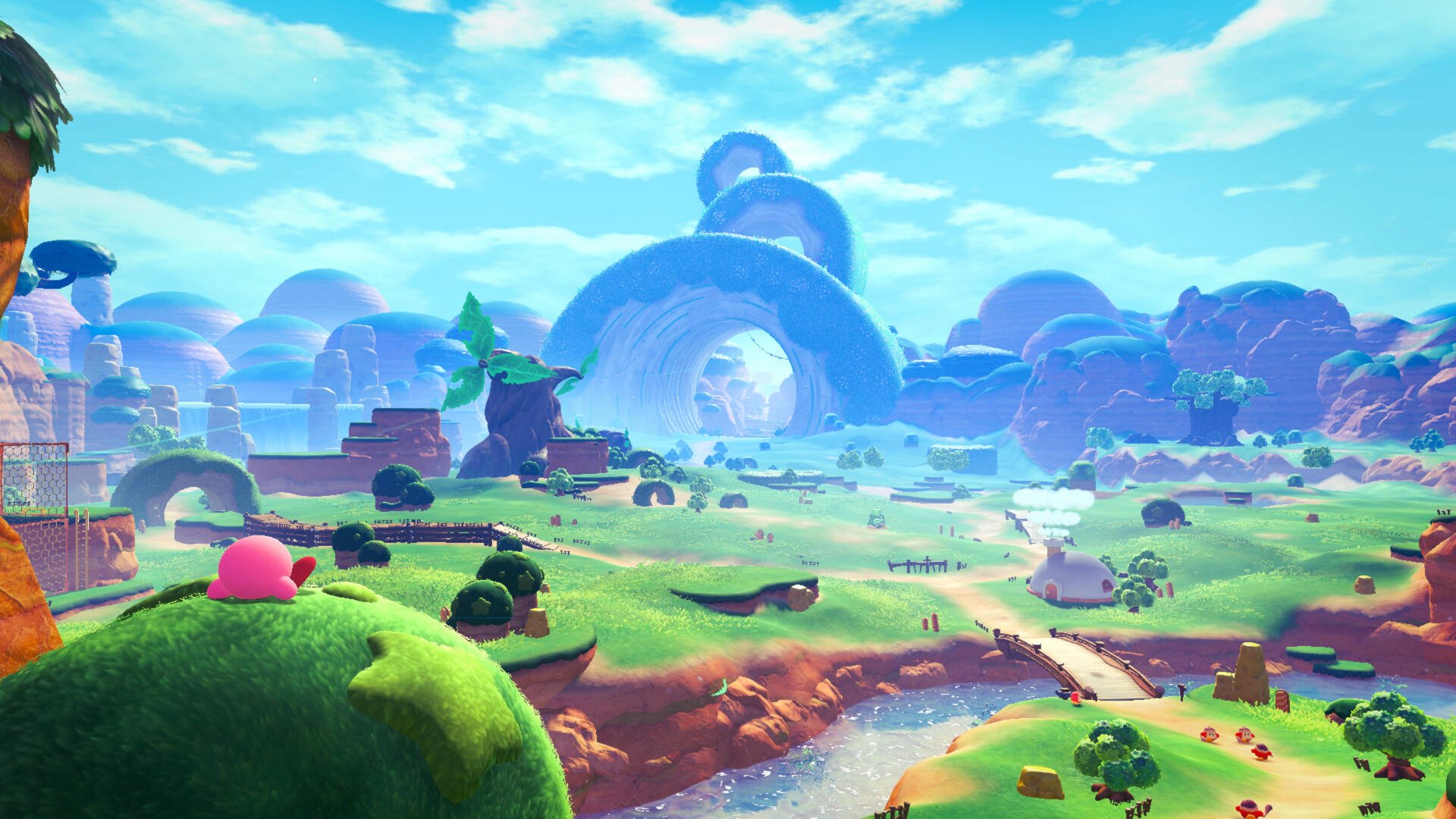 4K Ultra HD PC desktop wallpaper/background: Kirby and the World Beyond — Kirby perched on a lush meadow, overlooking rolling hills, a winding stream, and arching rock formations beneath a bright blue sky.