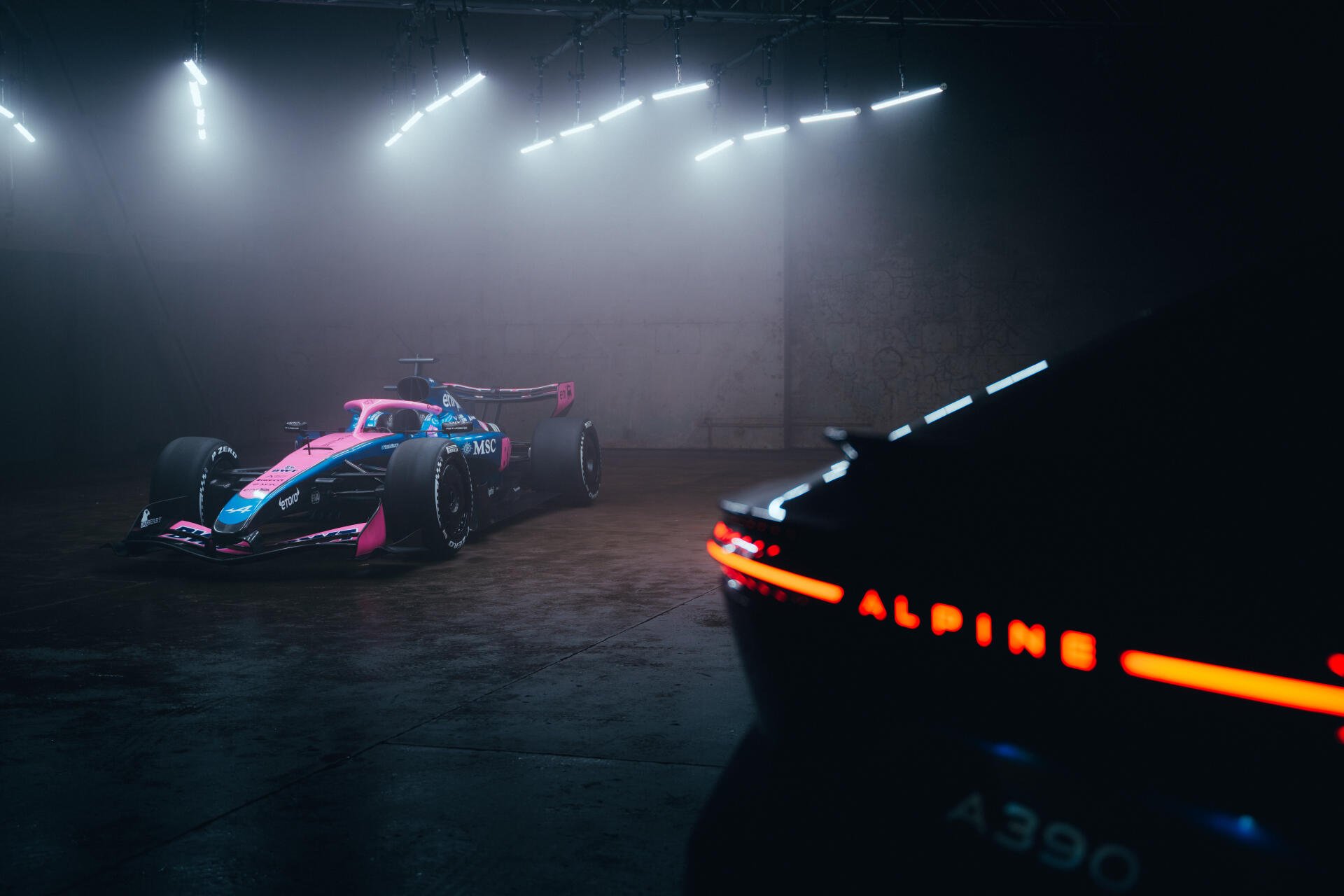 Alpine A526 F1 race car in a dramatic dark studio, featured in an 8K Ultra HD PC desktop wallpaper and background.