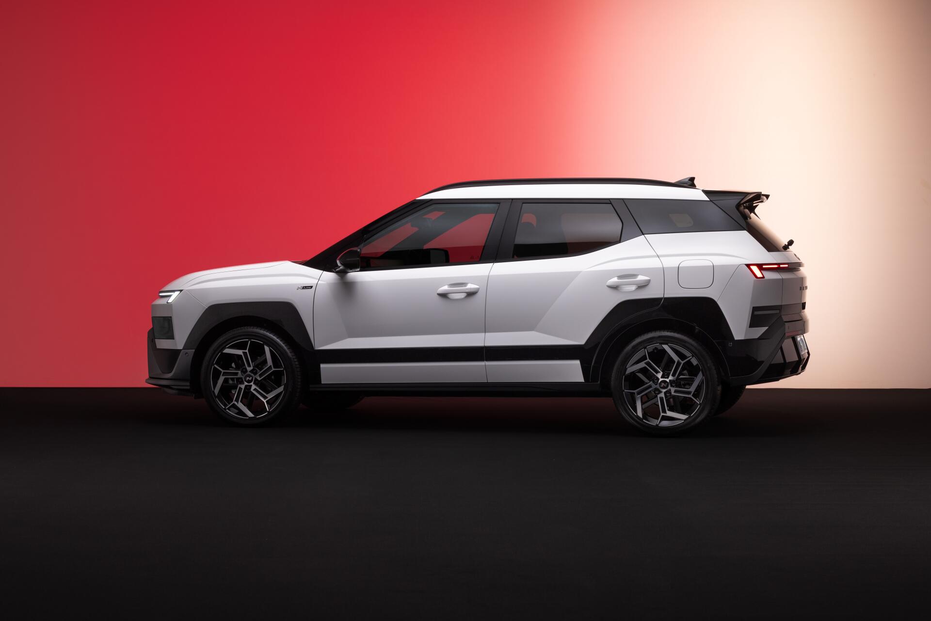 Silver Hyundai Bayon SUV in side profile against a red and cream backdrop, featured in an 8K Ultra HD PC desktop wallpaper.