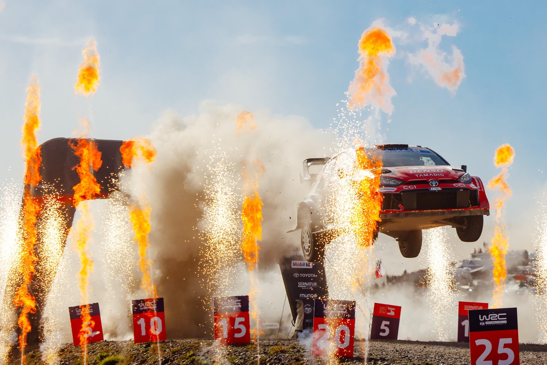 Toyota Gazoo Racing GR Yaris Rally1 airborne amid flames and sparks in a WRC scene, 4K Ultra HD desktop wallpaper.
