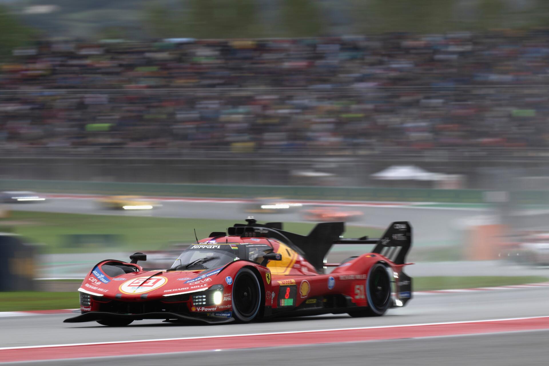 Ferrari 499P race car speeding past grandstands, featured in a 4K Ultra HD PC desktop wallpaper and background.