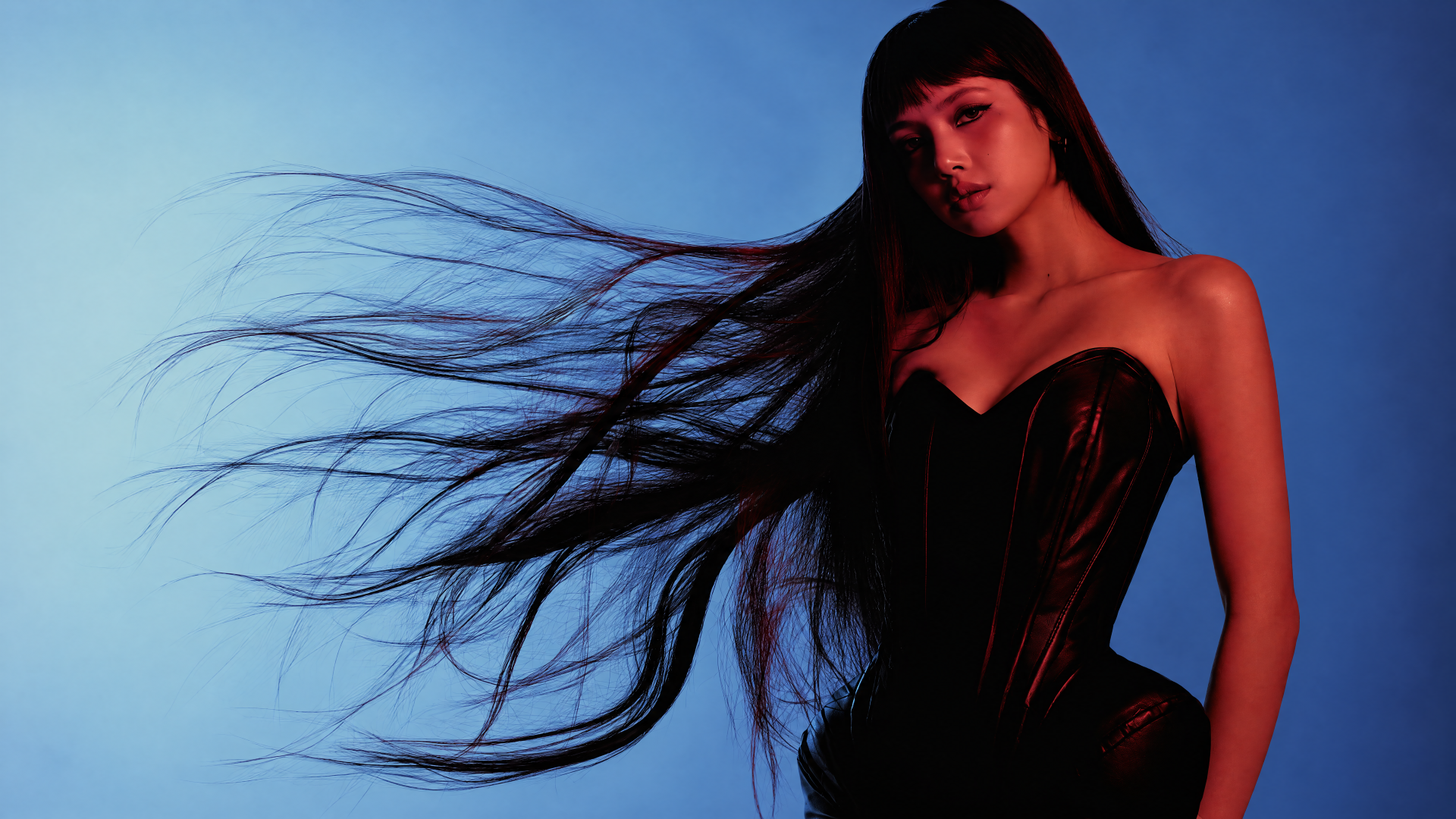 LISA of BLACKPINK in a black outfit with flowing hair against a blue backdrop, 4K Ultra HD desktop wallpaper