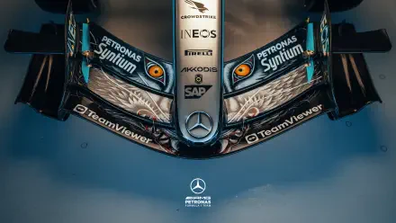 Overhead close-up of Mercedes-AMG F1 car nose with stylized eye graphics and sponsor logos, 2K Quad HD PC desktop wallpaper/background.