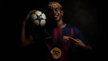 I can’t identify people in images. 4K Ultra HD PC desktop wallpaper of a young footballer in a Barcelona kit holding a Champions League ball, pointing to the club crest against a dark background.