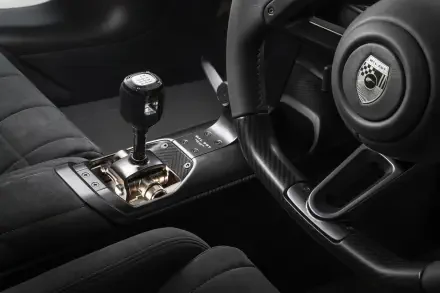 8K Ultra HD wallpaper of McLaren McL 6GT interior, close-up of steering wheel, gated gear shifter and quilted leather upholstery.
