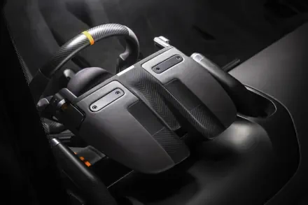 Close-up of McLaren McL 6GT vehicle controller-style center console in 8K Ultra HD PC desktop wallpaper, showing carbon-fiber paddles and ergonomic controls.