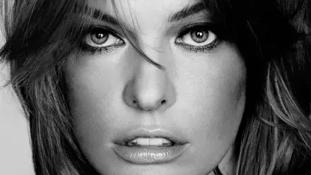 Black-and-white close-up HD PC desktop wallpaper of a woman's intense gaze, full lips, and tousled hair.