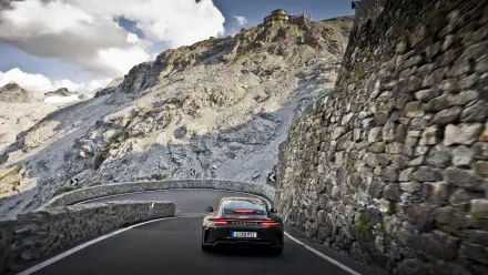 Rear view of a Porsche 911 GT3 sports car on a winding mountain road — 5K Ultra HD PC desktop wallpaper/background.