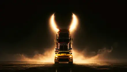 5K Ultra HD PC wallpaper: Optimus Prime's towering truck silhouette with Bumblebee in front, backlit by golden smoke and headlights forming a horned halo.