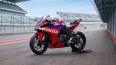 Red and blue Honda CBR500R Four sportbike on a racetrack, featured in a 5K Ultra HD PC desktop wallpaper background.