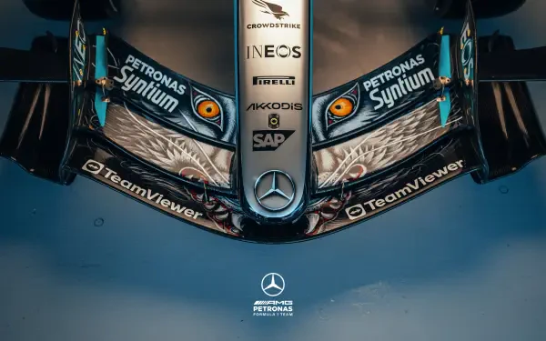 Overhead close-up of Mercedes-AMG F1 car nose with stylized eye graphics and sponsor logos, 2K Quad HD PC desktop wallpaper/background.
