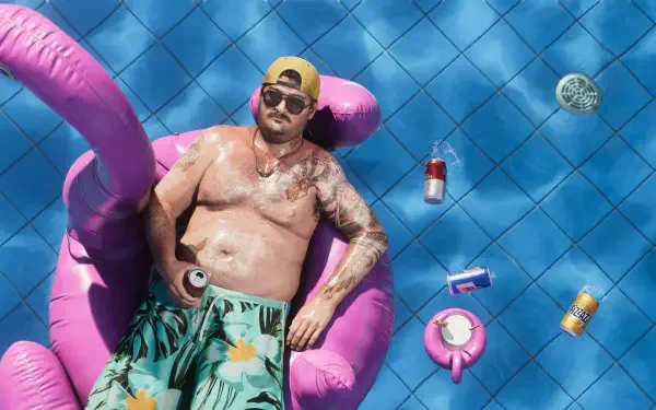 Video game-style Grand Theft Auto VI 4K PC wallpaper: shirtless man in sunglasses on a pink pool float amid beer cans and blue tiles, evoking a Cal Hampton / GTA vibe.