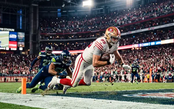 5K Ultra HD PC desktop wallpaper of a football player diving for a touchdown at the goal line in a packed stadium.